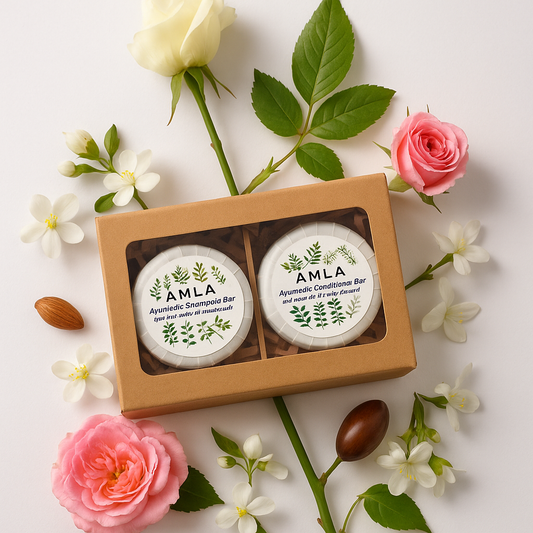 Two AMLA soap bars in a box with flowers and leaves on a light background