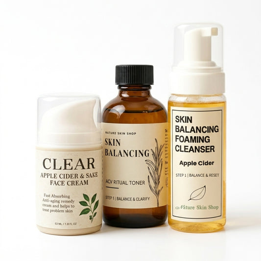 Three skincare products from Nature Skin Shop arranged on a white background: a Clear Apple Cider & Sake Face Cream jar, an Acy Ritual Toner bottle, and a Skin Balancing Foaming Cleanser pump bottle.