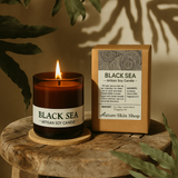 Black Sea artisan soy candle with packaging on a wooden surface Black Sea artisan soy candle with packaging on a wooden surface