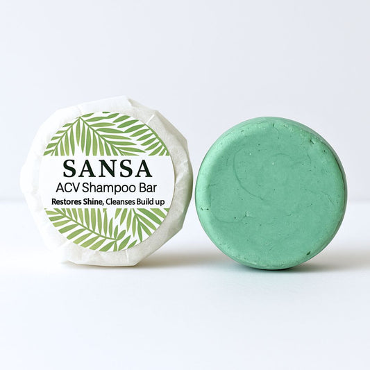 Green shampoo bar with packaging labeled 'Sansa ACV Shampoo Bar' on a white background