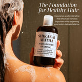 Person holding Shikakai Aritha hair growth shampoo bottle with text about healthy hair. Person holding Shikakai Aritha hair growth shampoo bottle with text about healthy hair.