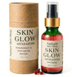 A bottle of Nature Skin Shop Skin Glow Astaxanthin anti-aging serum next to its brown kraft paper packaging cylinder, with a few red astaxanthin crystals in front, on a white background.