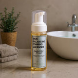 Foaming cleanser bottle labeled 'Skin Balancing Foaming Cleanser' with apple cider vinegar on a bathroom counter.
