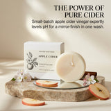 Nature Skin Shop Apple Cider Shine Ritual Bar soap displayed next to its white box on a marble slab, with apple slices and flowers, under the text 'THE POWER OF PURE CIDER'.