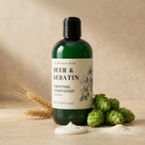 Green conditioner bottle labeled 'Beer & Keratin' with hop cones and wheat on a beige background