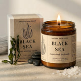 Black Sea candle from Nature Skin Shop with packaging and decorative elements on a neutral background
