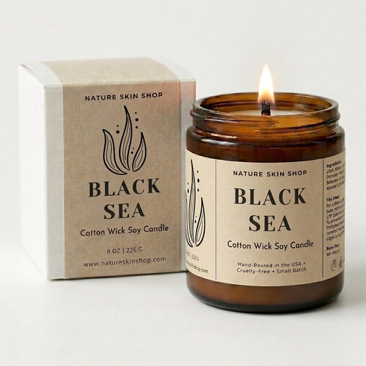 Brown candle labeled 'Black Sea' from Nature Skin Shop with a matching box on a white background
