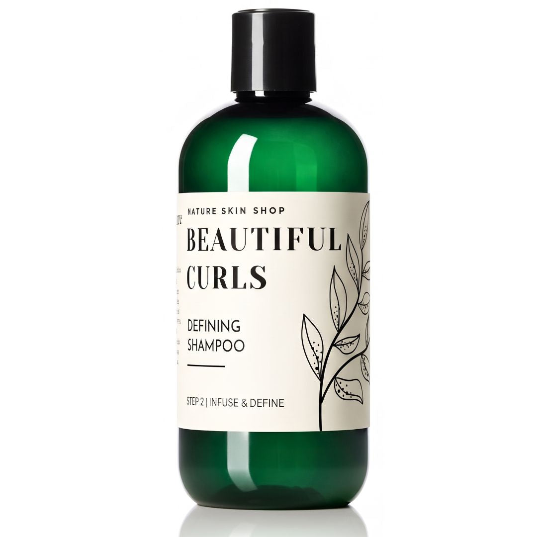 A bottle of Nature Skin Shop Beautiful Curls Defining Shampoo, featuring a dark green translucent bottle and a black cap, with a cream-colored label containing black text and botanical line art.