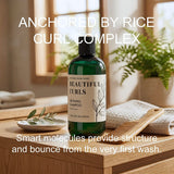 A bottle of Beautiful Curls Defining Shampoo stands on a wooden tray in a warm, softly lit bathroom-like setting with a plant, towel, and small dish. Large overlaid text reads 'ANCHORED BY RICE CURL COMPLEX' and 'Smart molecules provide structure and bounce from the very first wash.