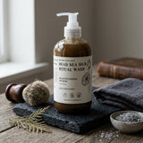 Bottle of Dead Sea Mud Ritual Wash on a wooden surface with natural elements.