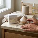 Mineral ritual bar on a stone surface with hands and other items in the background