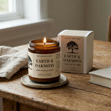 Earth & Oakmoss candle and packaging on a wooden surface with natural light