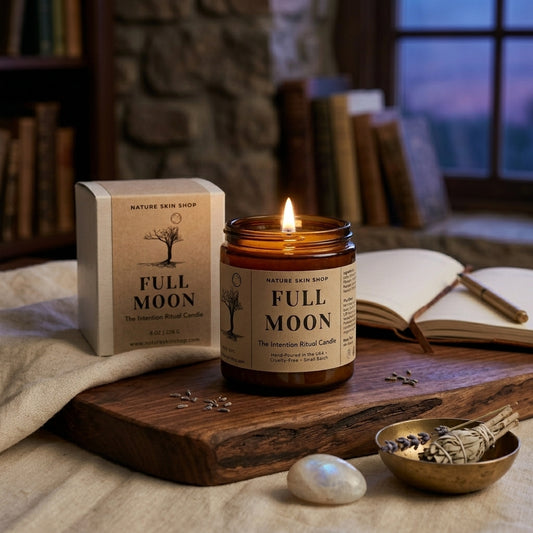 Full Moon candle from Nature Skin Shop on a wooden surface with books and a stone wall in the background.