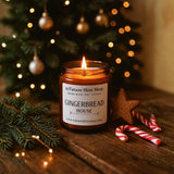 Candle labeled 'Gingerbread House' from Nature Skin Shop on a wooden surface with Christmas decorations.