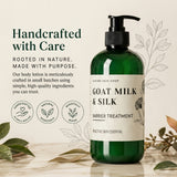 A green pump bottle of Nature Skin Shop Goat Milk & Silk Barrier Treatment stands on a light surface with decorative leaves around it. The bottle has a black pump and a cream label with dark green text.