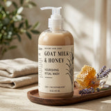 A pump bottle of Nature Skin Shop Goat Milk & Honey Nourishing Ritual Wash sits on a wooden tray in a warm, styled setting with a folded beige towel, greenery, a glass bowl of honeycomb, and lavender sprigs.