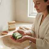 Woman holding a bar of soap in a bathroom setting