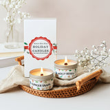 Two lit candles on a tray with 'Nature Skin Shop Holiday Candles' packaging in the background.