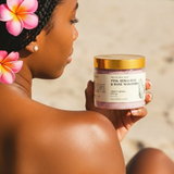 Woman holding a jar of Pink Himalayan and Rose Salt Scrub with flowers in her hair.