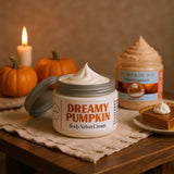 Jar of 'Dreamy Pumpkin' body velvet cream on a wooden table with pumpkins and a candle in the background.