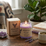 Phoenix candle from Nature Skin Shop on a wooden surface with a plant and books in the background
