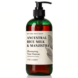 A bottle of Nature Skin Shop Ancestral Rice Milk & Manjistha Illuminating Face Cleanser, Step I | Purify. The product is in a dark amber green translucent bottle with a black pump dispenser and a cream-colored label featuring black text and botanical line art.