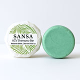 Green shampoo bar with packaging labeled 'Sansa ACV Shampoo Bar' on a white background