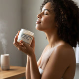 Woman holding a jar of Dead Sea Salt and Olive Oil product with a diffuser in the background