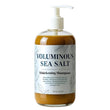 Bottle of voluminous sea salt thickening shampoo with a pump on a white background