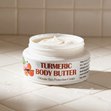 Jar of turmeric body butter on a tiled surface