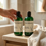 Two bottles of 'Voluminous' shampoo and conditioner on a bathroom counter.