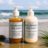 Two bottles of voluminous sea salt thickening shampoo and conditioner on a beach.