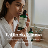 Woman holding a bottle of 'Voluminous' shampoo with text about its benefits.