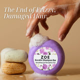 ZOE Keratin Shampoo Bar with a hand applying soap, on a beige background